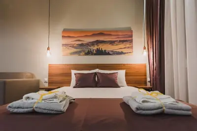 a bedroom with a bed with towels on it at Central Plaza Apartments in Niš