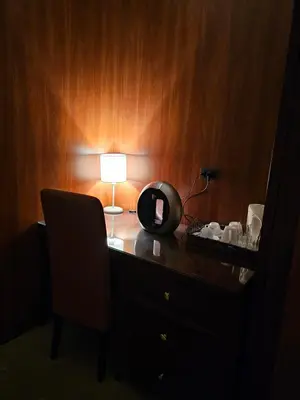 a desk with a lamp and a chair in a room at Central Plaza Apartments in Niš
