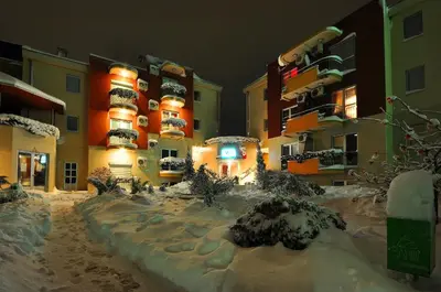 a snow covered street in front of a building at IWA CENTAR Apartments & Wellness in Vrnjačka Banja