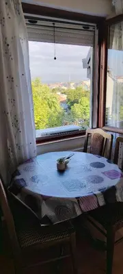 a table and chairs in a room with a window at Ćele-kula Apartment in Niš