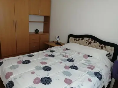 a bedroom with a bed with a floral comforter at Ćele-kula Apartment in Niš