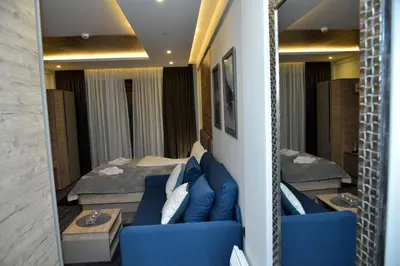 a living room with a blue couch and a table at Apartman Sladjana Premier 12 Milmari in Kopaonik