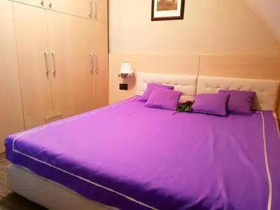 a bedroom with a purple bed with purple pillows at Apartment Superior Centar in Kopaonik