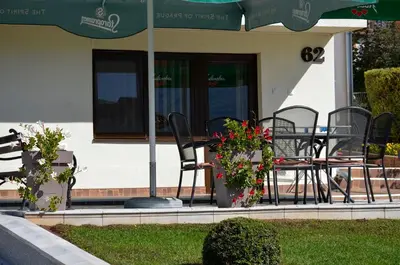 a patio with chairs and a table with flowers at Apartmani Janja in Soko Banja