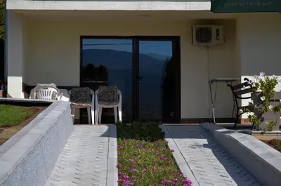 a house with a patio with chairs and flowers at Apartmani Janja in Soko Banja