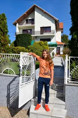 a young girl standing in front of a gate at Apartmani Janja in Soko Banja