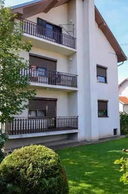 an apartment building with balconies and a yard at Apartmani Janja in Soko Banja