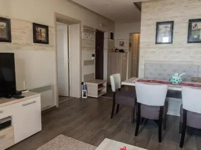 a kitchen and living room with a table and chairs at Fabulous Luxury Apartment G7 in Kopaonik