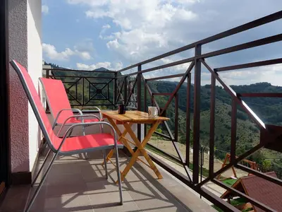 a balcony with two chairs and a table with a view at Fabulous Luxury Apartment G7 in Kopaonik