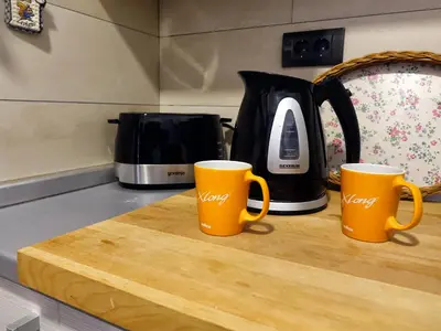 two orange coffee mugs sitting on a wooden cutting board at Fabulous Luxury Apartment G7 in Kopaonik
