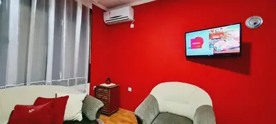 a red living room with a tv on a red wall at Felix Apartment in Soko Banja