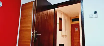 a wooden door in a room with a red wall at Felix Apartment in Soko Banja