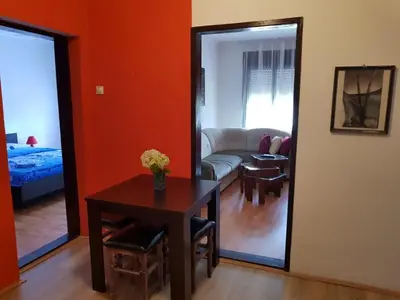 a room with a table and a living room at Felix Apartment in Soko Banja