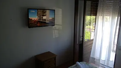 a flat screen tv hanging on a wall next to a window at Felix Apartment in Soko Banja