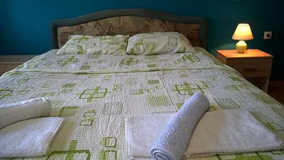 a bed with a blanket and pillows on it at Felix Apartment in Soko Banja