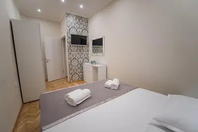 a bedroom with a bed with two towels on it at Center Deluxe Garni Hotel in Niš