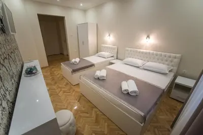 a room with two beds and a mirror at Center Deluxe Garni Hotel in Niš