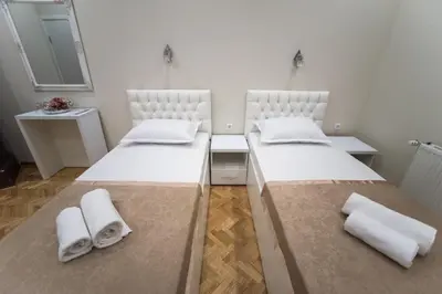 two beds in a small room with towels on them at Center Deluxe Garni Hotel in Niš