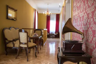 a room with chairs and a table and a dining room at Center Deluxe Garni Hotel in Niš
