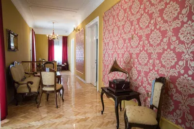 a room with chairs and a dining room with pink wallpaper at Center Deluxe Garni Hotel in Niš