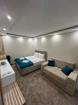 a living room with a bed and a couch at Center Deluxe Garni Hotel in Niš