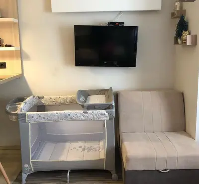 a room with a tv and a table and a chair at Tim 135 Konaci-Angella Centar in Kopaonik