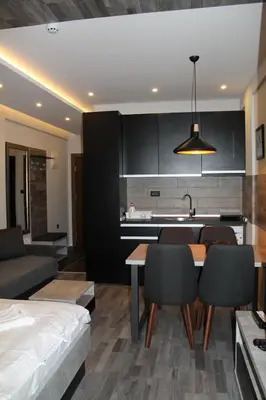 a kitchen and living room with a table and chairs at Lux Apartment Milmari Reko Premier 14 Kopaonik in Kopaonik