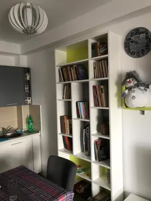a room with a book shelf with books and a clock at Apartman Biblioteka Čardaka 10/61 in Kopaonik