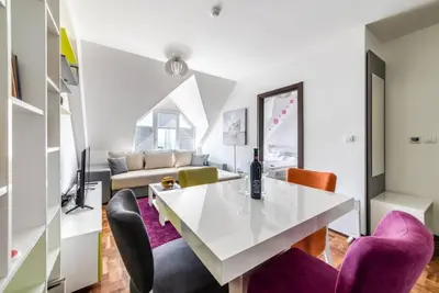 a living room with a white table and purple chairs at Apartman Biblioteka Čardaka 10/61 in Kopaonik