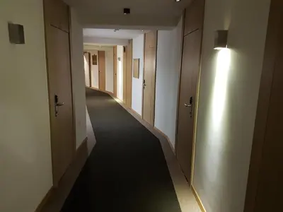 an empty hallway with doors and a long hallway with a light at Angella Konaci Kopaonik in Kopaonik