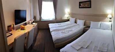 a hotel room with two beds and a television at Angella Konaci Kopaonik in Kopaonik
