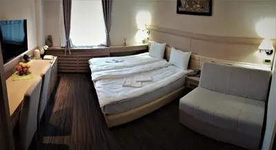 a hotel room with a large bed and a window at Angella Konaci Kopaonik in Kopaonik