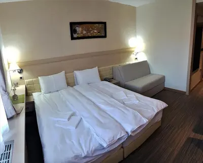 a bedroom with a large white bed and a chair at Angella Konaci Kopaonik in Kopaonik