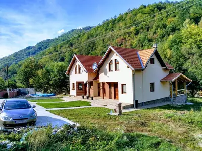 a house with a car parked in front of it at Vila Žubor in Crni Vrh