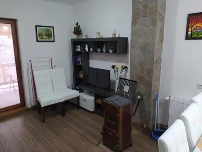 a living room with a tv and a couch and a chair at Vila Žubor in Crni Vrh