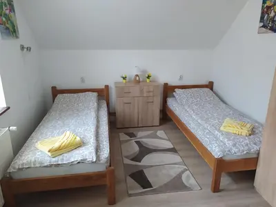 a room with two beds and a dresser at Vila Žubor in Crni Vrh