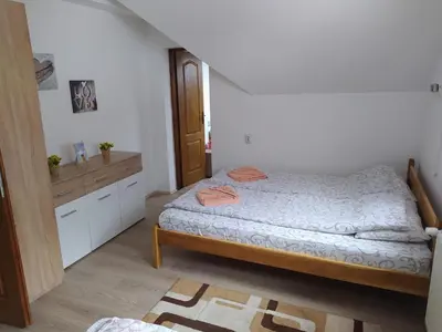 a small bedroom with a bed and a kitchen at Vila Žubor in Crni Vrh