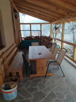 a wooden table and chairs in a room with a bench at Vila Žubor in Crni Vrh