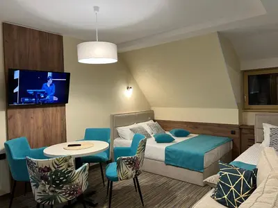 a hotel room with a bed and a tv at Select Lux Angella-Konaci in Kopaonik