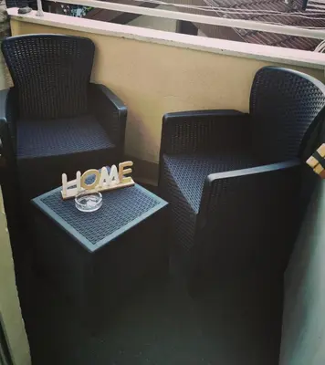 a pair of chairs with a clock and a love sign at City Center Apartment JOTIC in Pirot