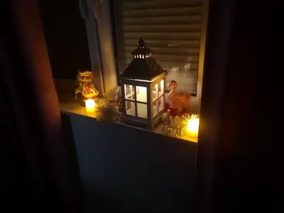 a window sill with a lantern and christmas lights at City Center Apartment JOTIC in Pirot