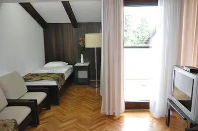 a hotel room with two beds and a television at Hotel Simpo Pržar in Vranje