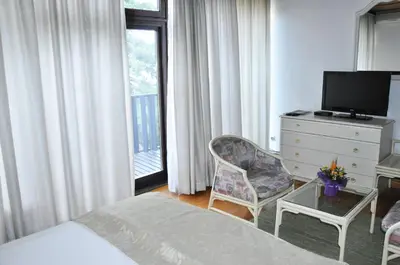 a hotel room with a bed and a dresser and a television at Hotel Simpo Pržar in Vranje