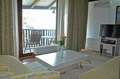 a living room with a couch and a table and a television at Hotel Simpo Pržar in Vranje