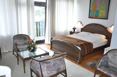 a bedroom with a bed and a table and chairs at Hotel Simpo Pržar in Vranje