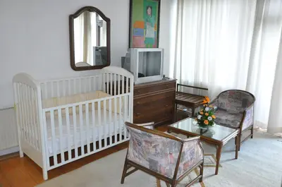a living room with a crib and a tv at Hotel Simpo Pržar in Vranje