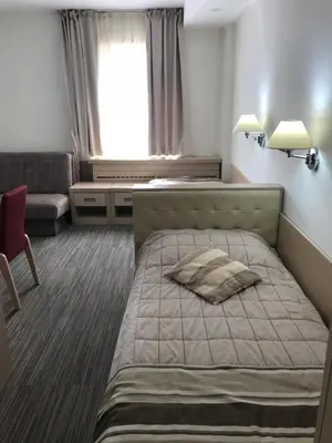 a bedroom with a bed and a couch and a window at Apartman Konaci Maglic in Kopaonik