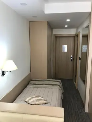 a bedroom with a bed with a lamp and a door at Apartman Konaci Maglic in Kopaonik