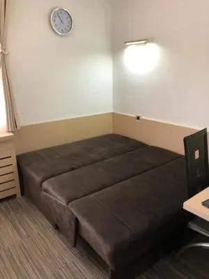 a bed in a room with a clock on the wall at Apartman Viktor in Kopaonik