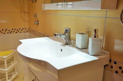 a bathroom with a white sink and two soap dispensers at Stella Apartments in Vrnjačka Banja